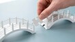 © Asghar - Business strategy concept with a hand placing a puzzle piece to complete a bridge, representing connection, planning, and problem solving