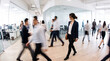 © Rustem - Businesswoman walking through a modern office with motion-blurred coworkers