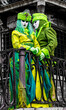 © Travel 'n' Lifestyle - View of two people wearing elaborate green and yellow costumes and masks standing on a balcony during the Venice Carnival in Venice, Veneto, Italy.