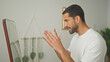 © Krakenimages.com - Man in white t shirt displays thumbs up and gesturing hands toward mirror in studio, alternating clapping and pointing in a short sequence; encouragement self reflection progress.