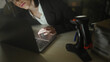 © Krakenimages.com - Hispanic woman business worker in blazer leans on hand while looking at laptop keyboard beside lamp in office at night; late night fatigue.