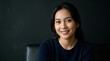 © Fani - Portrait of a smiling young Asian woman on a dark background
