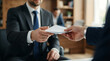 © Pipasha - Professional businessman receiving white envelope in office, corporate bribe or bonus payment concept, hands passing secret document