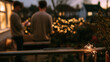 © lemonmoon - Festive sparkler glow on metal railing beside blurred people and garden lights at twilight