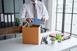 © Charlie's - Businessman Carrying Cardboard Box packing Stuff Resign Depress or carrying business cardboard box Change of job or fired from company resign.