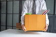 © Charlie's - Businessman Carrying Cardboard Box packing Stuff Resign Depress or carrying business cardboard box Change of job or fired from company resign.