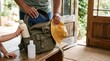 © krismicrostoker - Someone organizes a backpack with personal items on rustic wooden surface