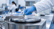 © Vector S J - Gloved hand operating heavy industrial centrifuge machine in modern medical laboratory.