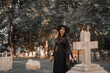 © Kieng - A mysterious witch in a black costume reaches toward the viewer while sitting in a dark cemetery, creating a creepy and supernatural Halloween atmosphere.