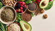 © dinatychynska - Top-down fibermaxxing food selection with lentils, chickpeas, avocado, oats, berries and seeds, healthy high-fiber nutrition trend composition.