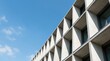 © An - A concrete building with a distinctive geometric facade features a series of horizontal, triangular fins.