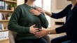 © Adil - Adult practicing deep breathing exercise with hands on chest and abdomen for mindfulness