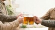 © Elenba - Friends toasting with beer steins in a casual outdoor setting. Celebration and friendship concept
