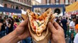 © Lina - Person holding folded Neapolitan pizza in brown paper at street food festival. Traditional Italian pizza a portafoglio in Naples