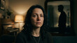 © NeeNA - Sad woman crying on sofa, emotional expression, dimly lit room, man silhouette in background