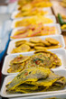 © 완수 안 - Assorted savory pan fried pancakes in styrofoam trays lined in a row are displayed for sale at a traditional five day market in South Korea.