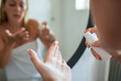 © Marko Geber - Woman applying face moisturizer at bathroom mirror