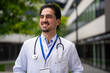 © Jelena - Confident male doctor smiling outside hospital building