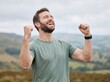 © Ikhbal - Successful man raising fists in celebration on outdoor mountain