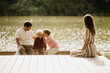 © BGStock72 - Joyful family moments by the tranquil lake on a sunny afternoon