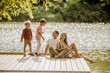 © BGStock72 - Family enjoying a sunny day by the tranquil lakeside