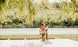 © BGStock72 - Couple enjoys a sunny day on a peaceful lakeside deck