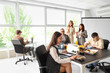 © Pixel-Shot - Group of business people having lunch at table in office