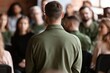 © Dekap - Rear view of a man standing before a seated audience in a seminar or training workshop room