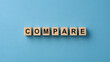 © Akash - The word compare spelled with wooden blocks on a blue background. Excellent concept for business analysis and decision making presentations.