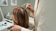 © Anna - Professional trichologist examining female patient hair and scalp in clinic