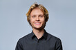© Valerii Honcharuk - Close up portrait of smiling young man looking directly at camera against grey background
