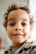 © TrueFrame Collective - Vertical portrait of African American child smiling during pediatrician visit. Visual useful for pediatric healthcare marketing, childcare clinic promotion