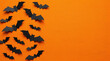 © litel.machine - Halloween black paper bats flying on an orange background with copy space