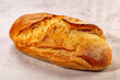 © Andrei Starostin - Freshly baked artisan sourdough loaf with golden crust and flour dusting on neutral textured surface