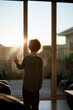 © Andrii Zastrozhnov - Child silhouette at glass sliding door at sunset for home interior mood and storytelling with warm golden light and calm atmosphere