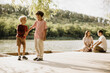 © BGStock72 - Two boys enjoy a joyful moment at the lakeside with friends nearby
