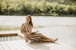 © BGStock72 - Relaxing by the serene lake while enjoying a good book and coffee