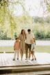 © BGStock72 - Family enjoying a sunny day by the serene lake surrounded by nature