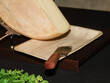 © Colombe Delons - Demi-meule de fromage à raclette fondant sous un appareil chauffant avec spatule de service