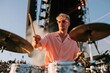 © Iryna - Focused drummer in pink shirt playing drums on open air festival stage for concert poster and music background design