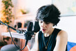 © Daniel Gonzalez/Stocksy - Woman recording music in home studio creating podcast