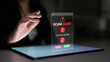 © InfiniteFlow - A woman interacts with a tablet displaying a scam alert notification, emphasizing the importance of cybersecurity awareness in today digital age, particularly during nighttime. Nascent