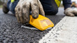 © Vera - Raised pavement marker installation by worker on asphalt surface