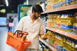 © Serhii - Indian man shopping cooking oil in supermarket aisle