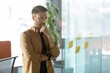© Prostock-studio - Focused Male Professional With Light Skin Tone, Standing In Modern Office While Thinking Deeply About Strategy And Plans. Setting With Glass Wall And Stick Notes. Business Concept.