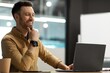 © Prostock-studio - Smiling Caucasian Man In His 30s Working On Laptop, Observing Screen With Interest And Happiness In Modern Office Environment, Focused On Task. Business Concept.