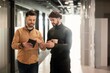 © Prostock-studio - Focused Men Discussing Ideas And Strategies While Looking At Tablet In Contemporary Office Environment, Collaborating On Project. Professional Setting With Modern Design, Business Concept.