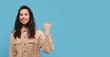 © Prostock-studio - Cheerful Young Woman Smiling And Pointing At Camera, Showcasing Positive Emotion In A Studio Setting With Blue Background. Engaging Expression Representing Happiness And Confidence.