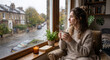 © Slowlife  - Solo person holding coffee mug looking out rainy window.