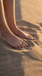 © Rendara Studio - Close detail of bare feet standing firmly in soft warm golden beach sand